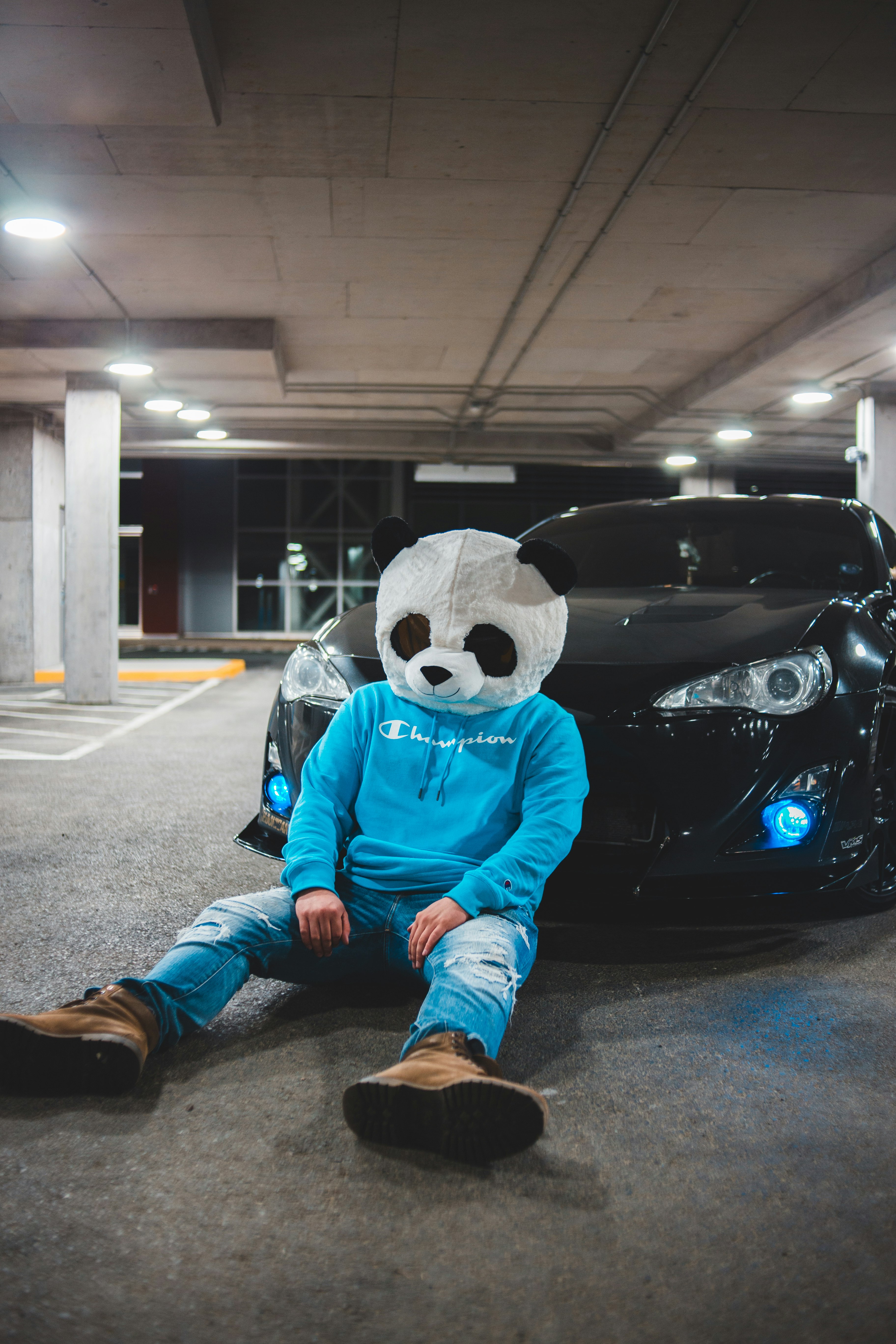 person in blue and black panda costume sitting on black car